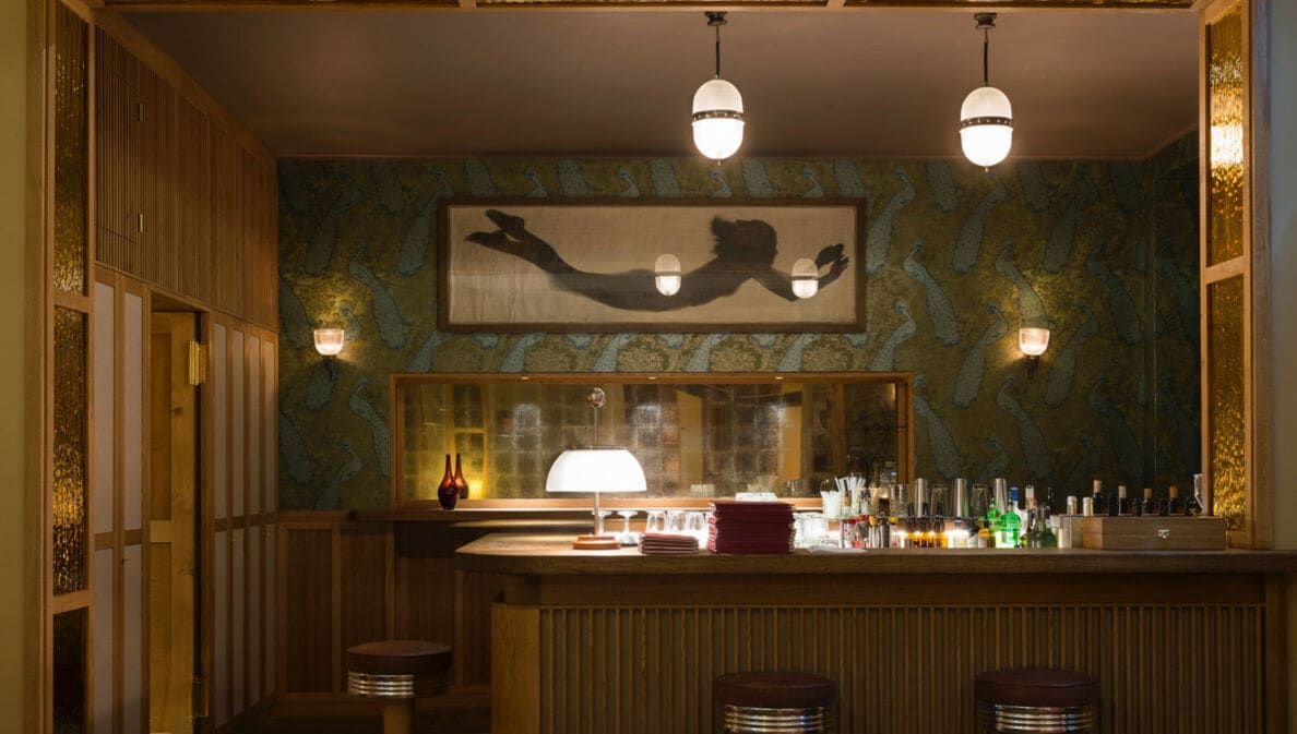 Ein holzverkleideter Tresen in einer modernen Bar mit gedimmter Beleuchtung.