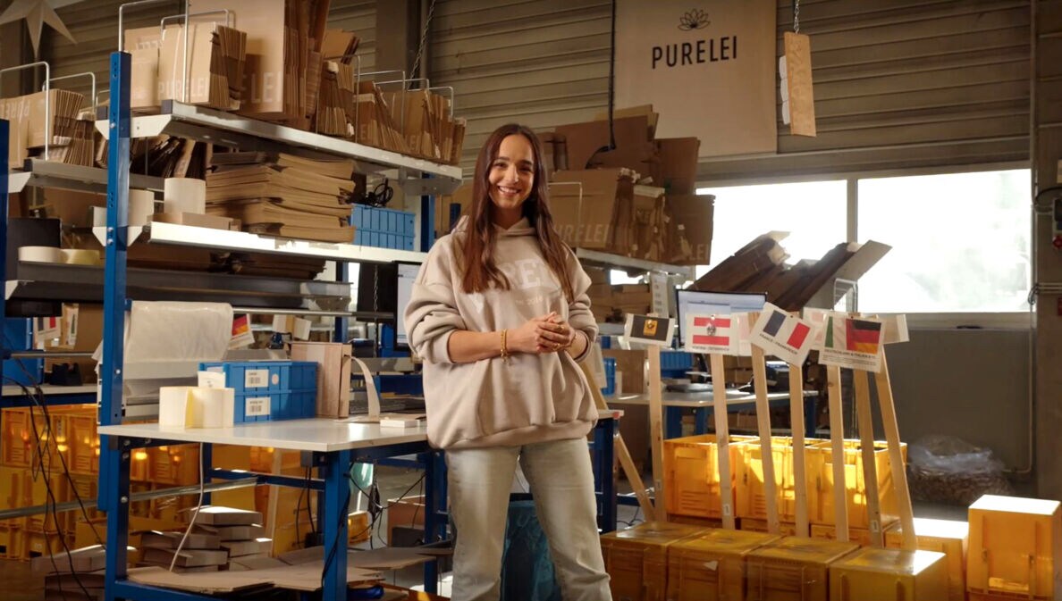 Alisa Jahnke, Co-Founderin von PURELEI steht in einem Lagerraum.