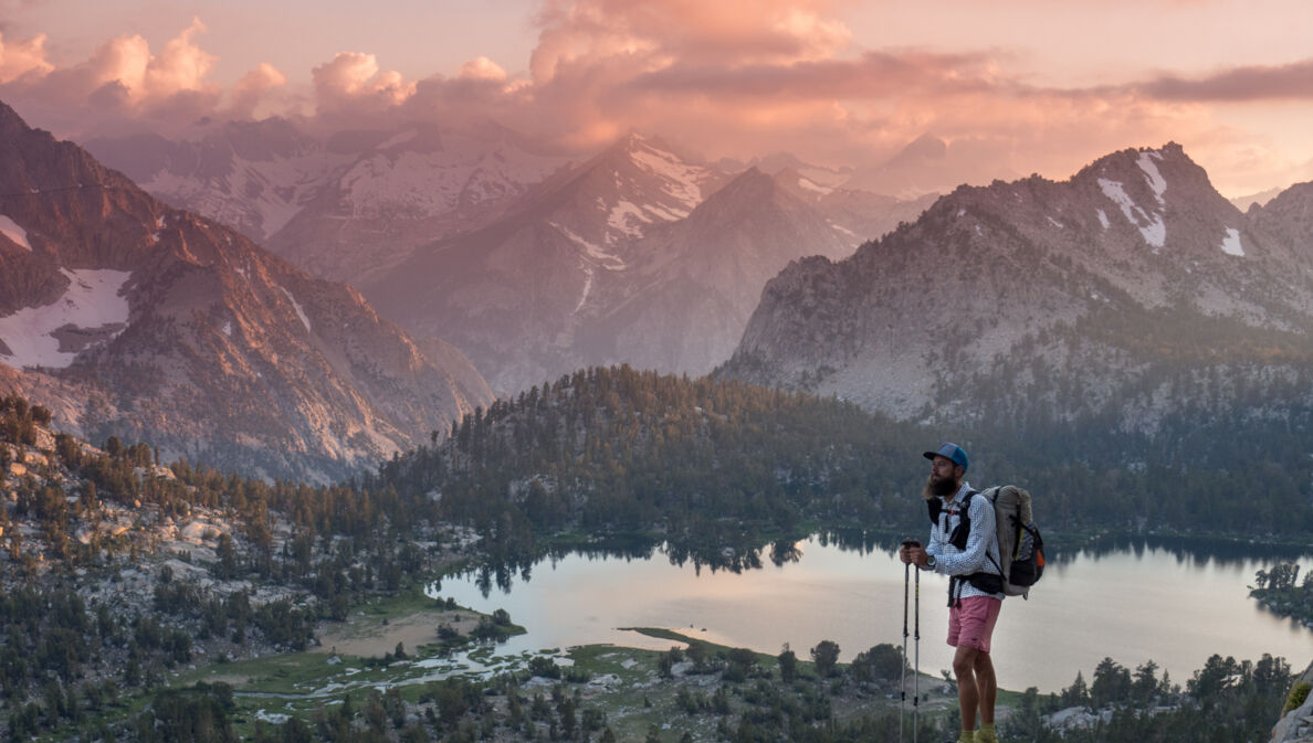 Florian Astor genießt die Aussicht oberhalb eines Bergsees während seiner Wanderung durch Neuseeland.