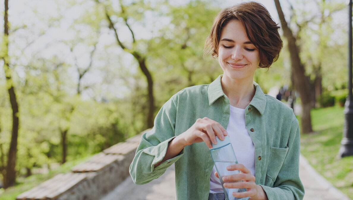Eine junge Frau macht bei schönem Wetter einen Spaziergang in der Mittagspause.