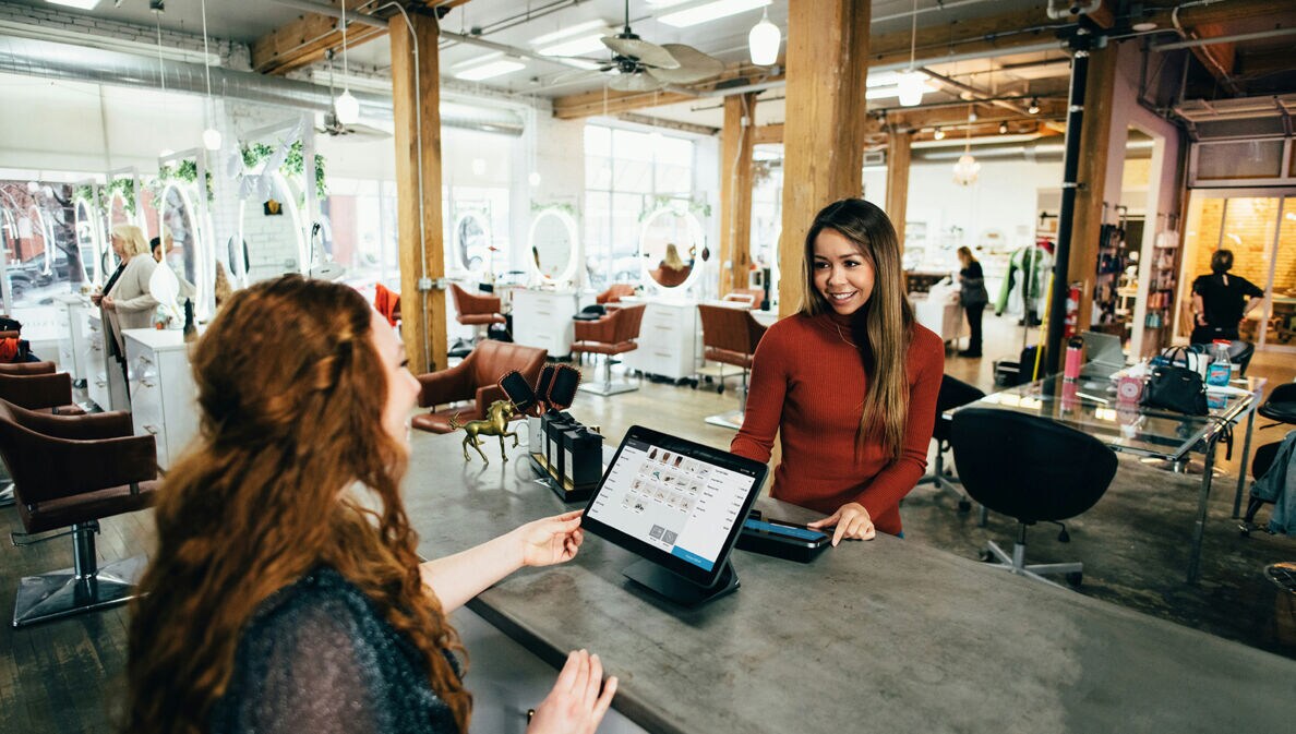 Eine Frau bezahlt im Beautysalon mit Karte.