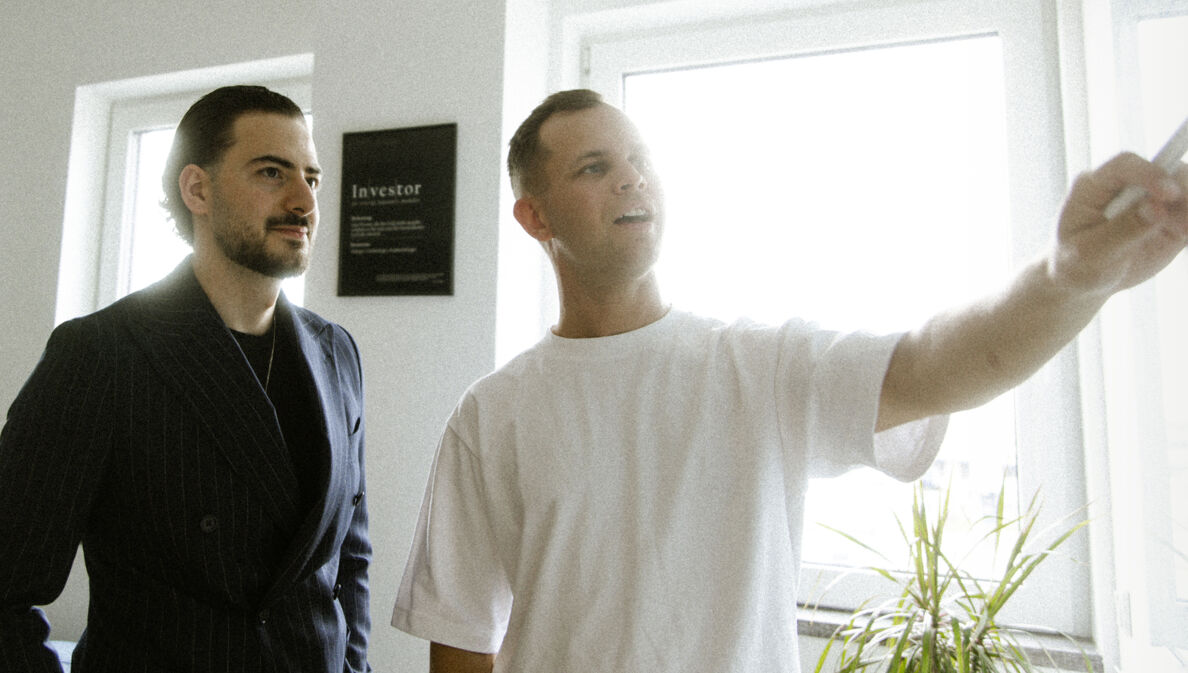 Kamiar Bar Bar und Benjamin Diedering stehen an einem Whiteboard.