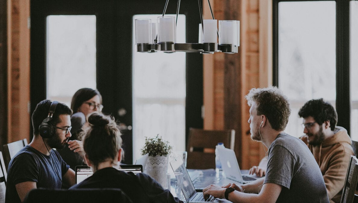 Ein junges Team arbeitet gemeinsam am Konferenztisch.