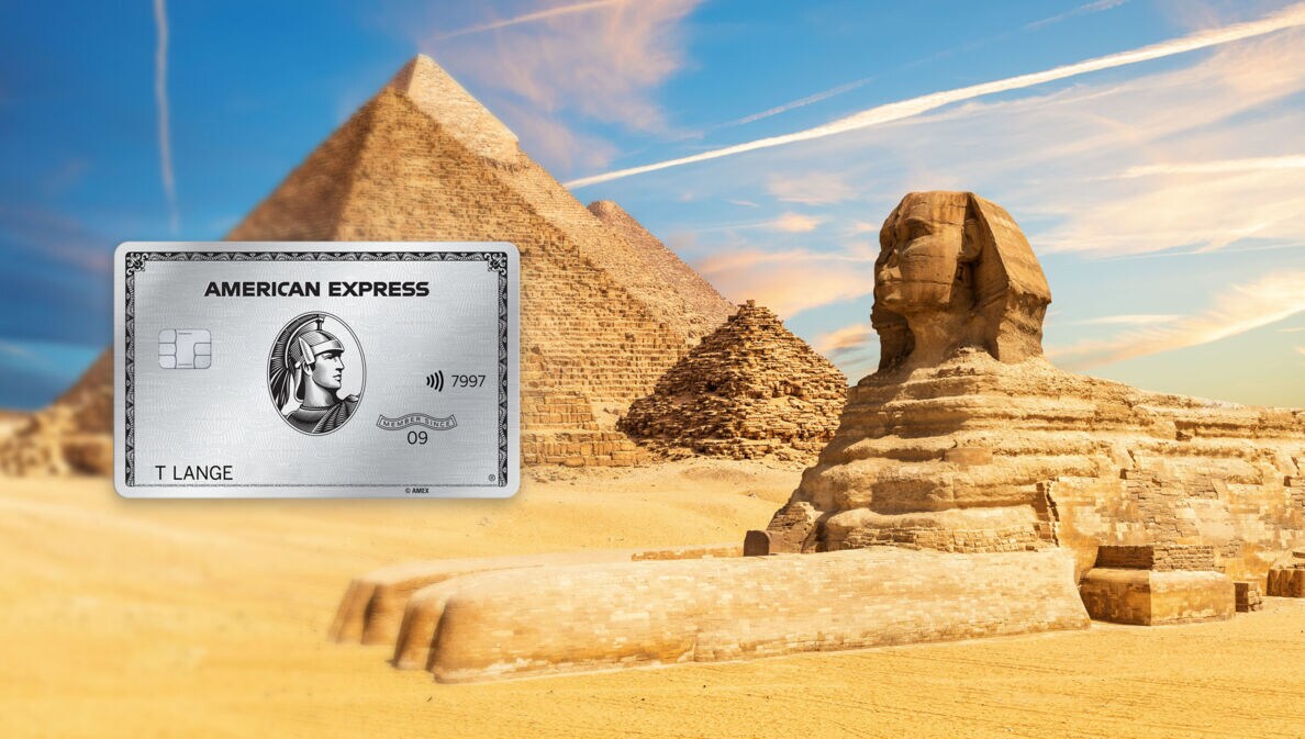 Sphinx Statue neben den Pyramiden von Gizeh in Wüstenlandschaft, im Vordergrund eine silberne Kreditkarte von American Express als Freisteller.