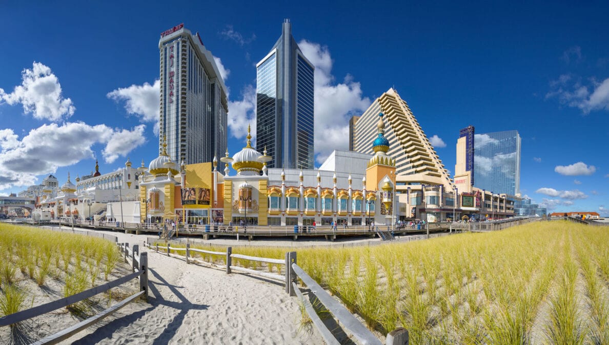 Strandpromenade mit Gebäude im orientalischen Stil vor Hochhäusern unter blauem Himmel.