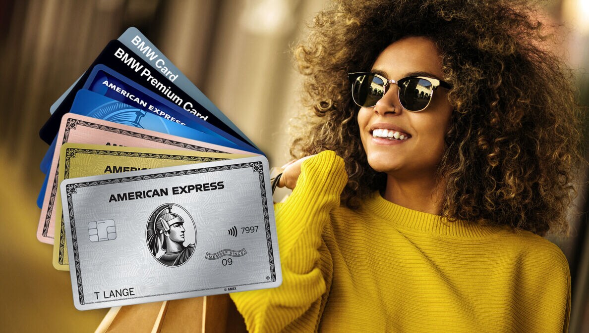 Sieben aufgefächerte Kreditkarten von American Express, im Hintergrund eine lachende Frau mit Sonnenbrille und Einkaufstüten über der Schulter.
