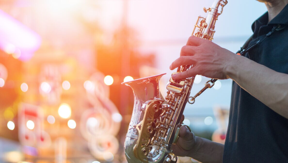 Ein Saxphonspieler steht auf einer Bühne.