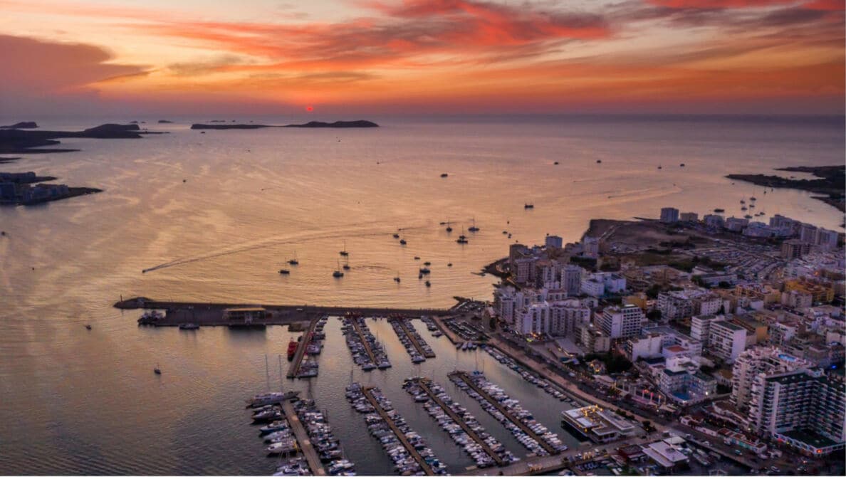 Luftaufnahme eines Hafens mit vielen Booten und Yachten bei Sonnenuntergang mit orangefarbenem Himmel