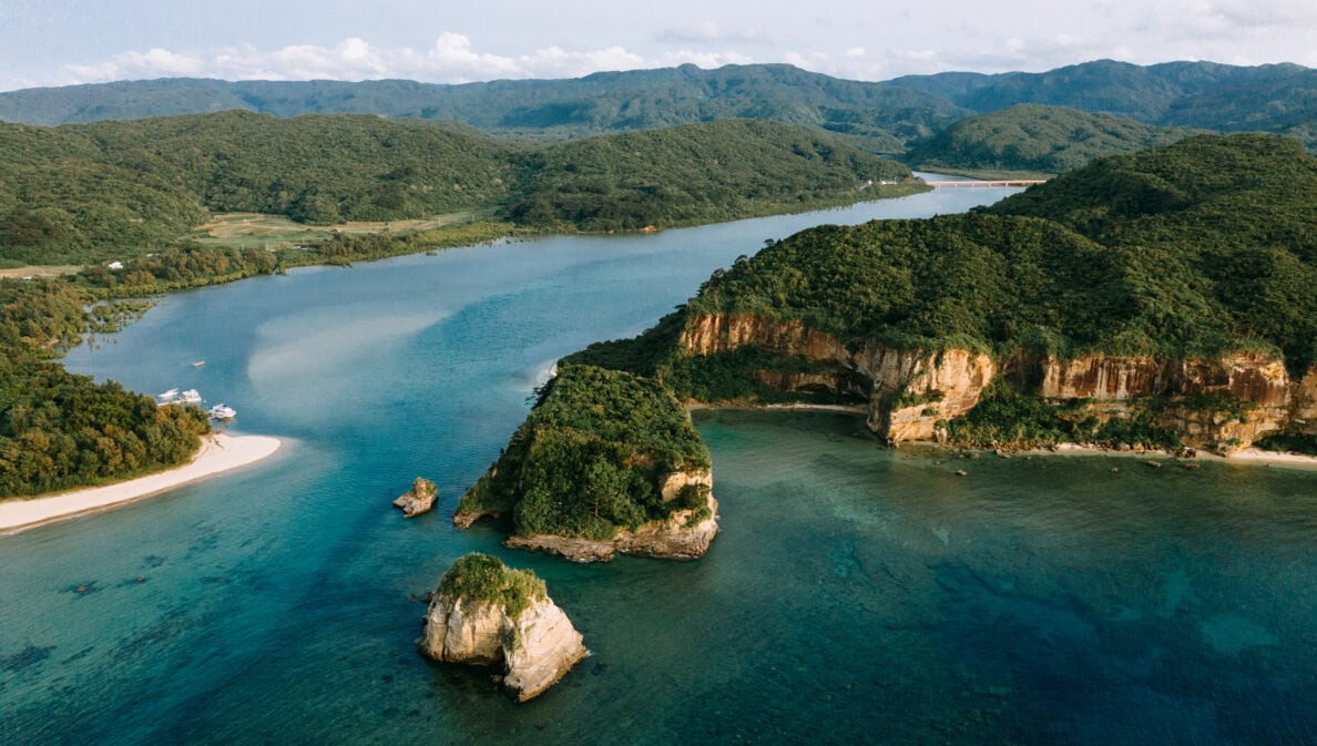 Luftaufnahme einer Inselgruppe mit bewaldeten Hügeln.