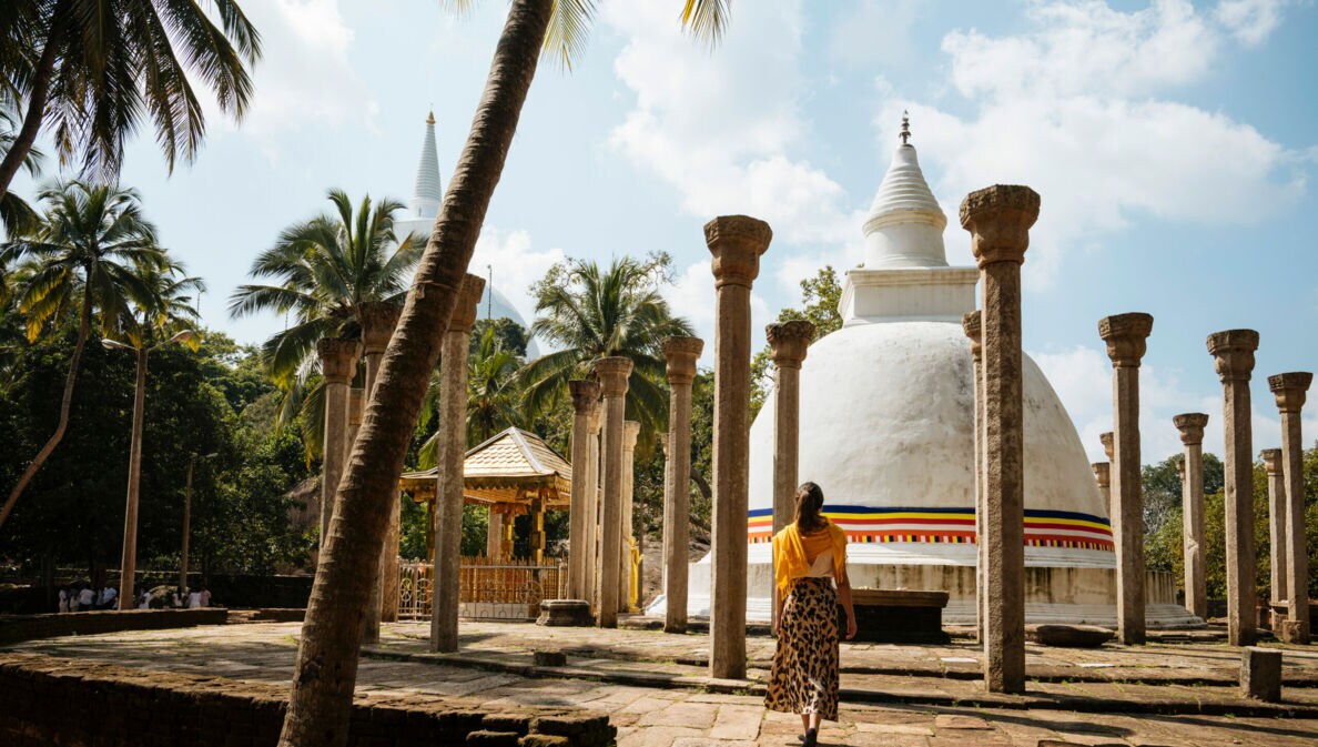Rückansicht einer Frau in einer Tempelanlage in Sri Lanka.