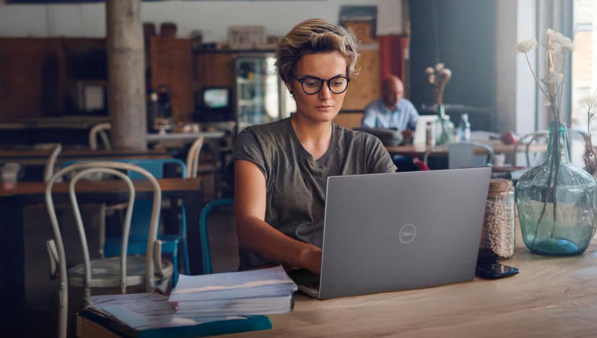 Eine Frau arbeitet in einem Café am Laptop.