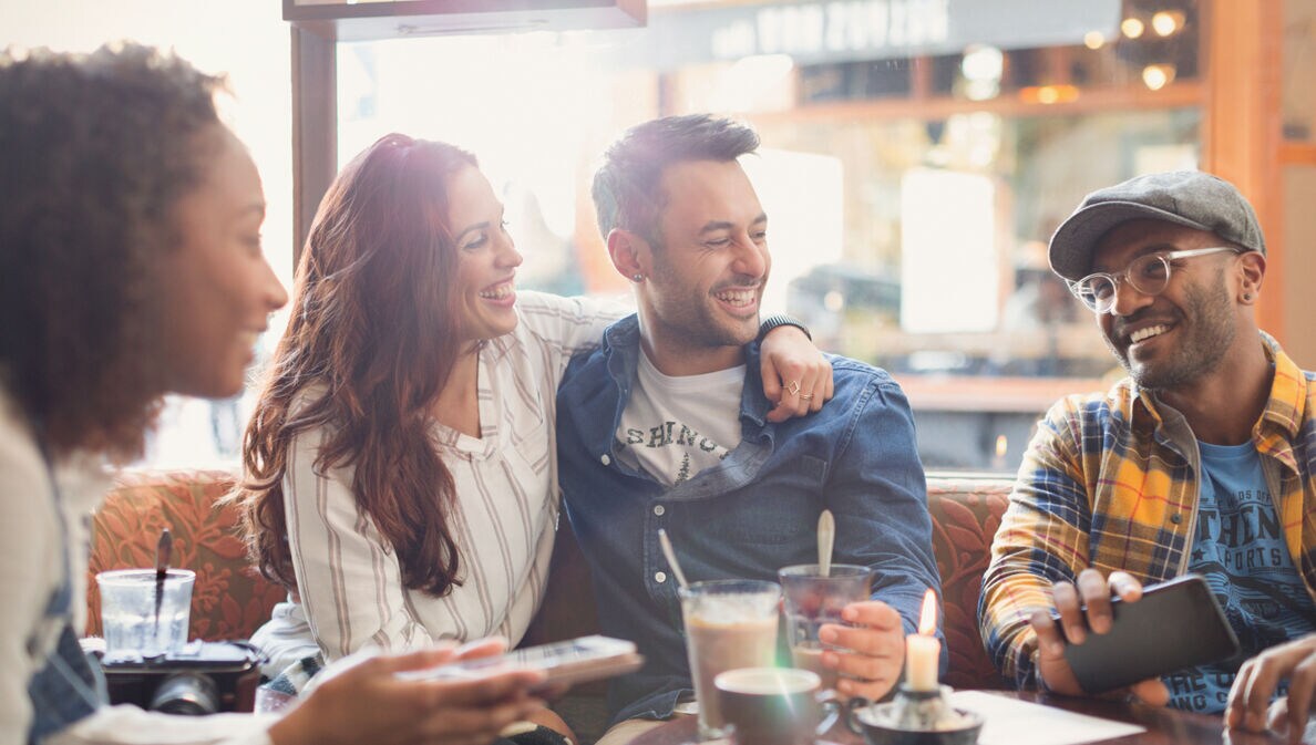 Gäste im Restaurant nutzen eine Buchhaltungsapp auf dem Smartphone.