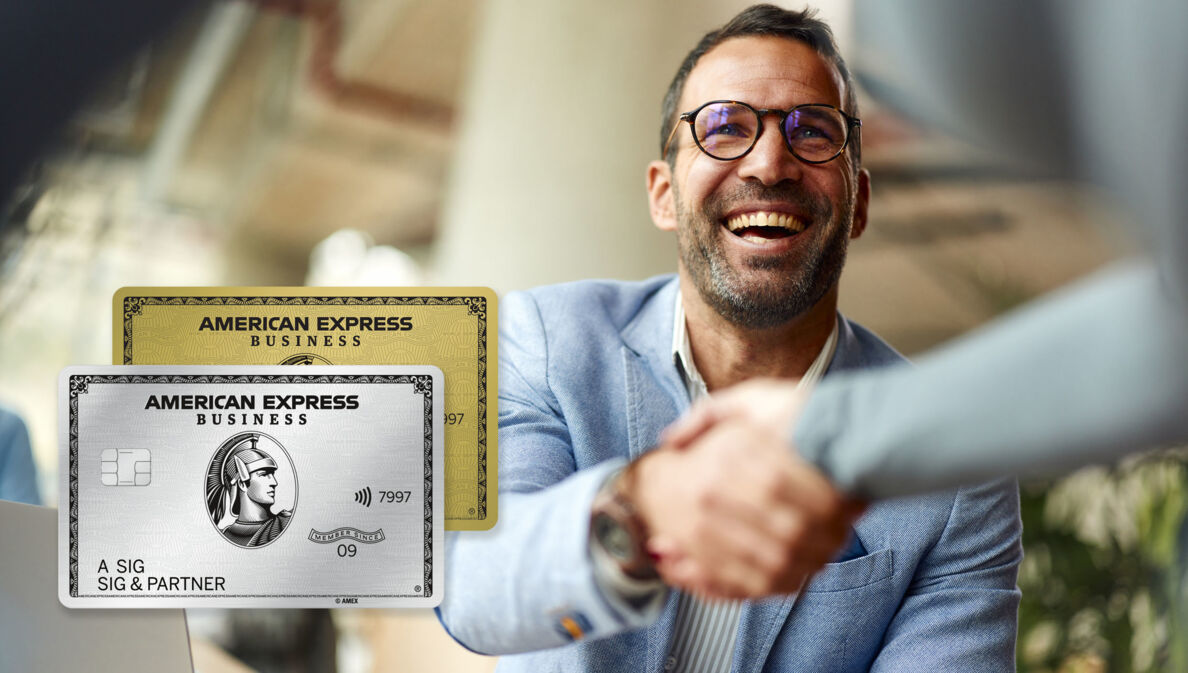 Ein lächelnder Mann im hellblauen Sakko schüttelt einer Person die Hand.