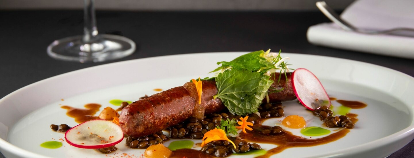 Eine Bratwurst, hübsch angerichtet auf einem Teller