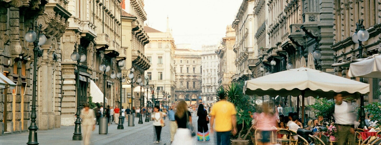 Menschen auf einer belebten Straße mit Bars und Restaurants in Mailand