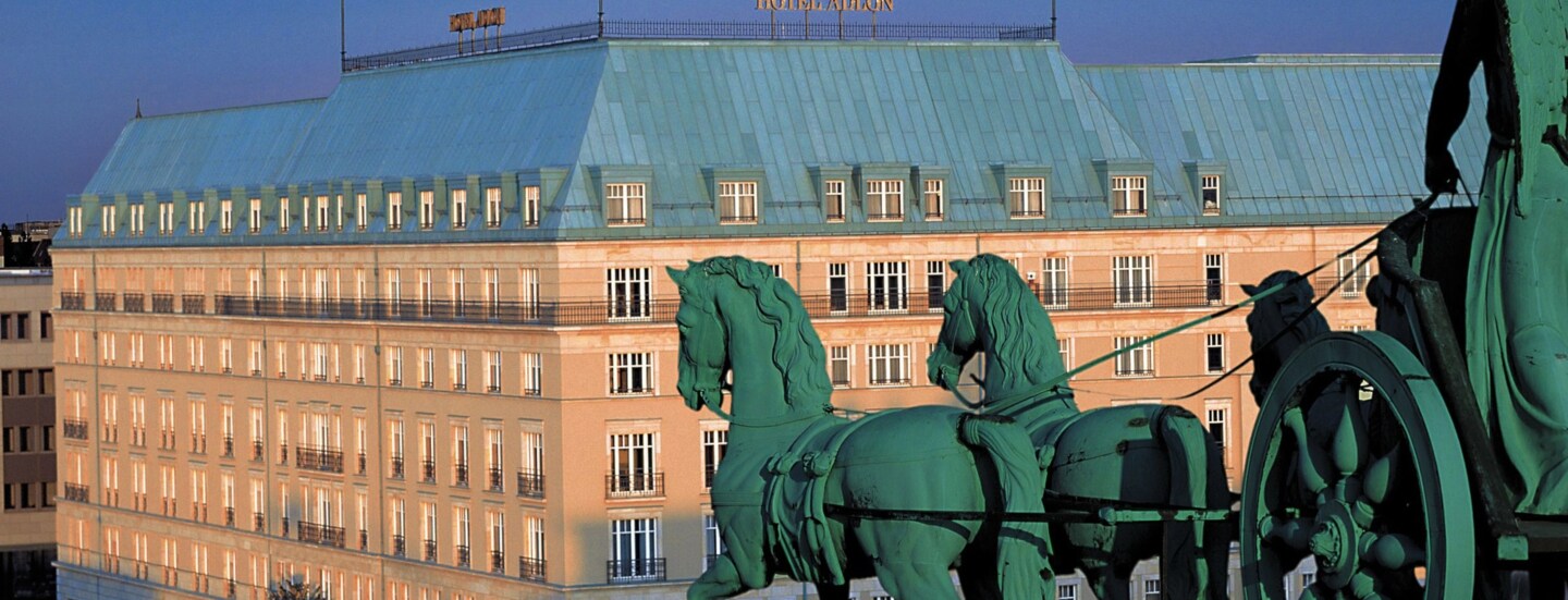 Luftaufnahme der Außenfassade des Hotel Adlon am Pariser Platz mit der Quadriga am Brandenburger Tor im Vordergrund.