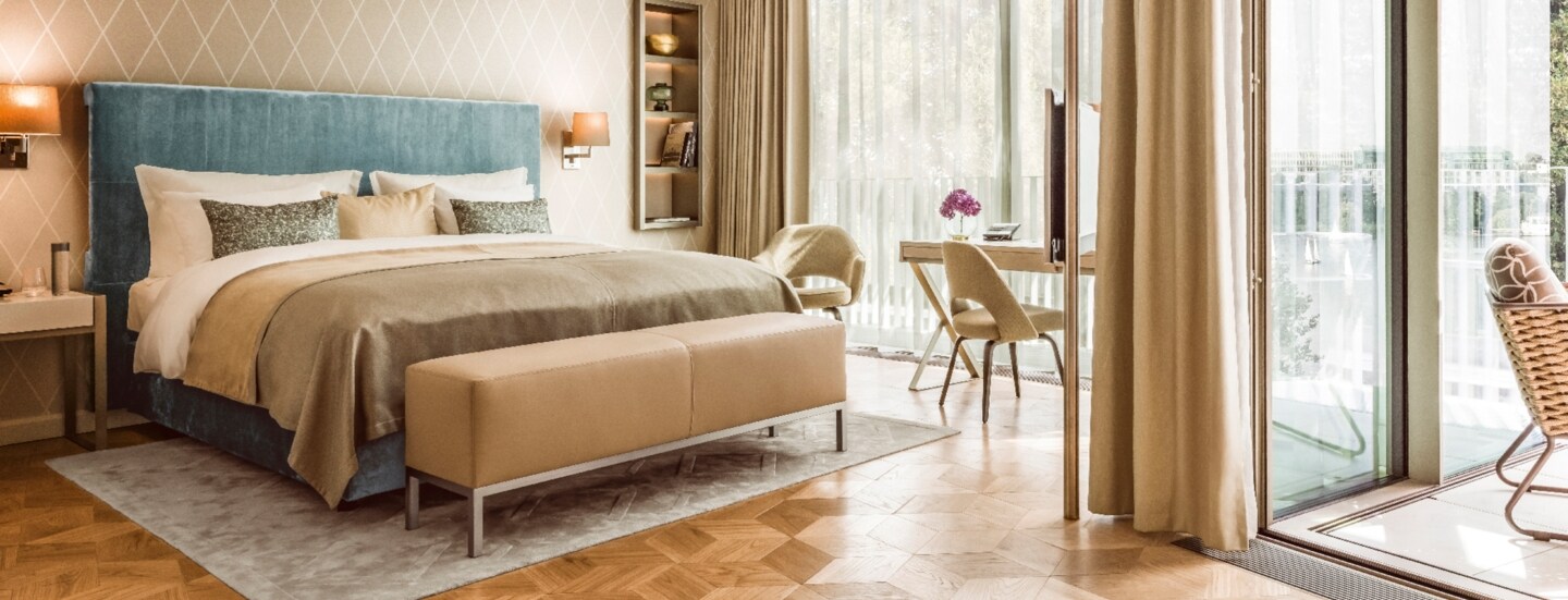 Moderne, helle Hotelsuite mit Parkettboden und bodentiefen Fenstern.