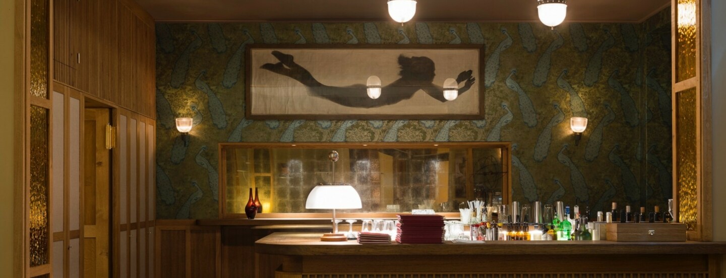 Ein holzverkleideter Tresen in einer modernen Bar mit gedimmter Beleuchtung.