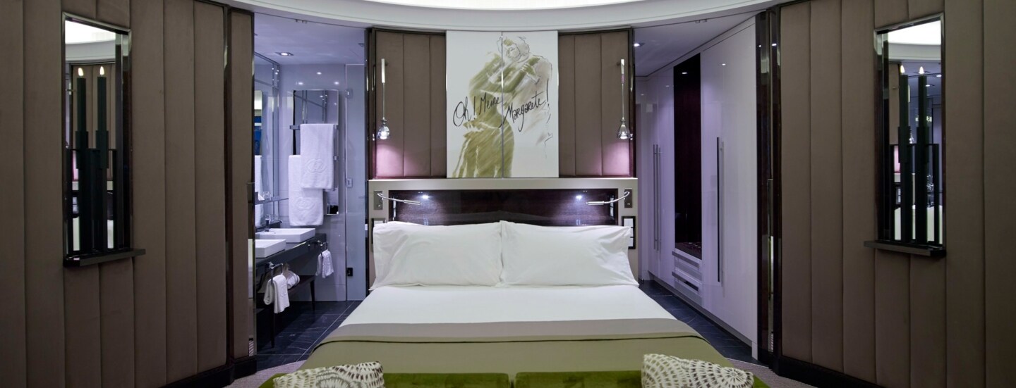 Eine moderne Hotelsuite mit runden Wänden und Doppelbett.