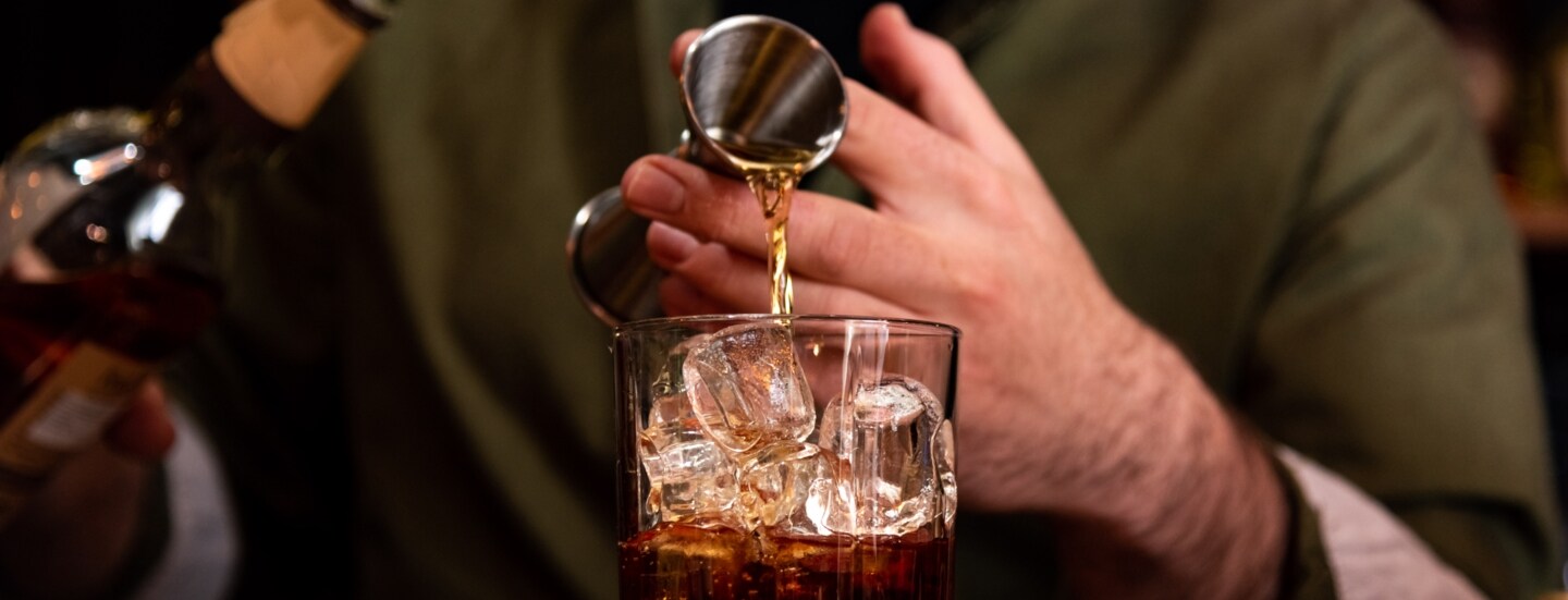 Ein Barkeeper gießt ein Glas Whisky ein.