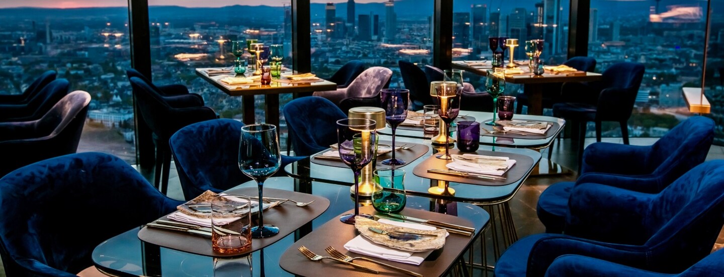 Räumlichkeiten des Restaurant Franziska mit der Skyline Frankfurts im Hintergrund.