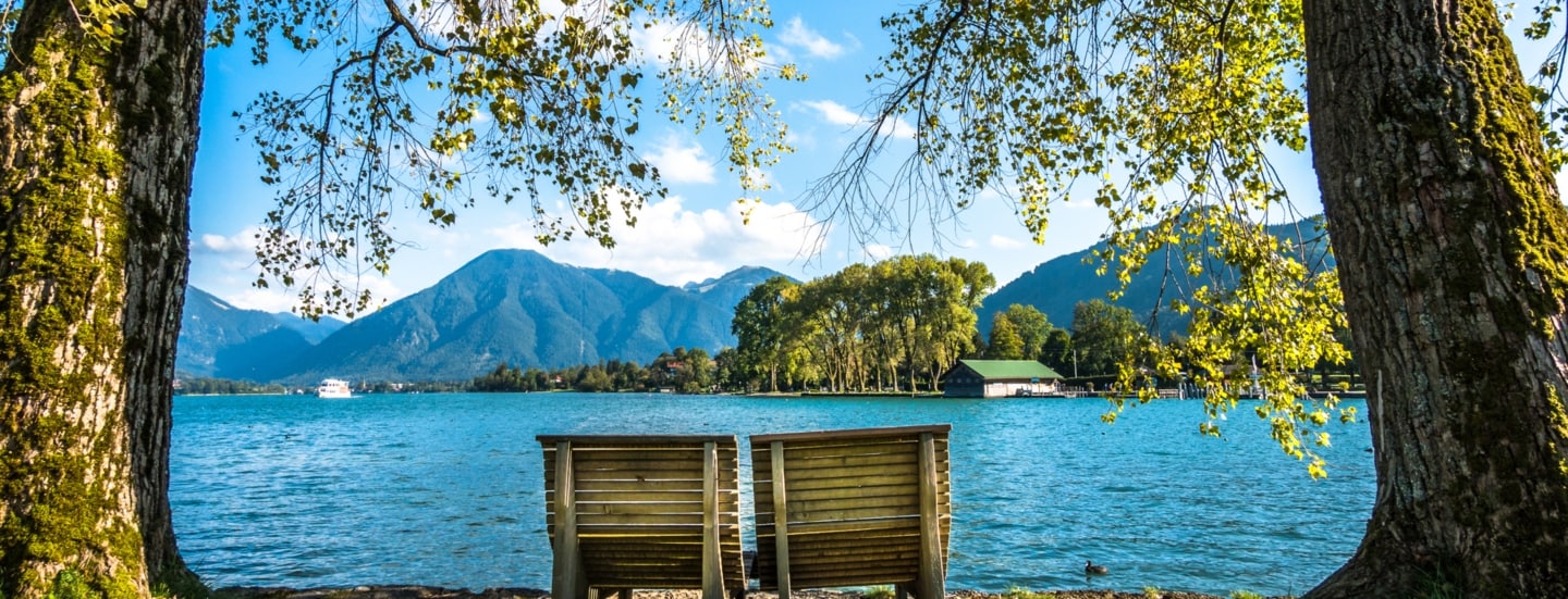 Zwei Holzliegen am Ufer des Tegernsees.