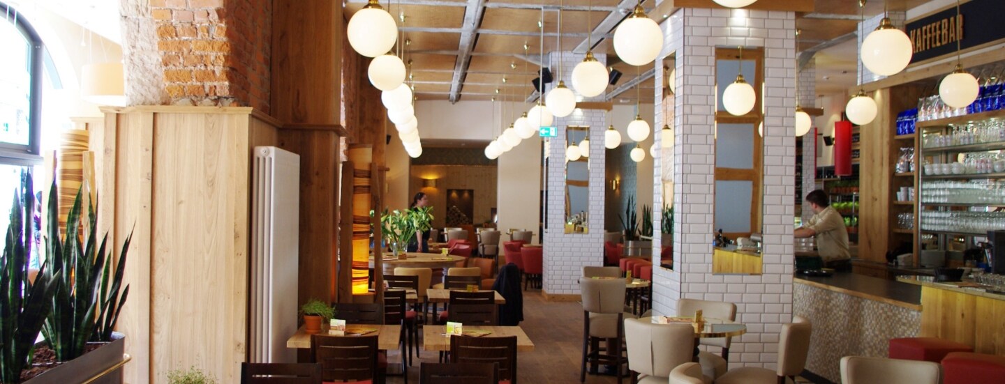 Modernes Bistro mit eklektischer Einrichtung in einem historischen Gebäude.