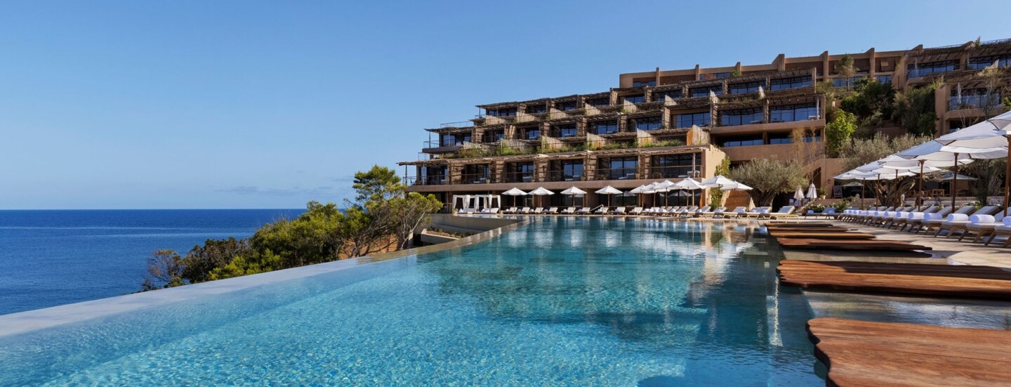 Hotelkomplex mit Infinitypool an einer Meeresküste.