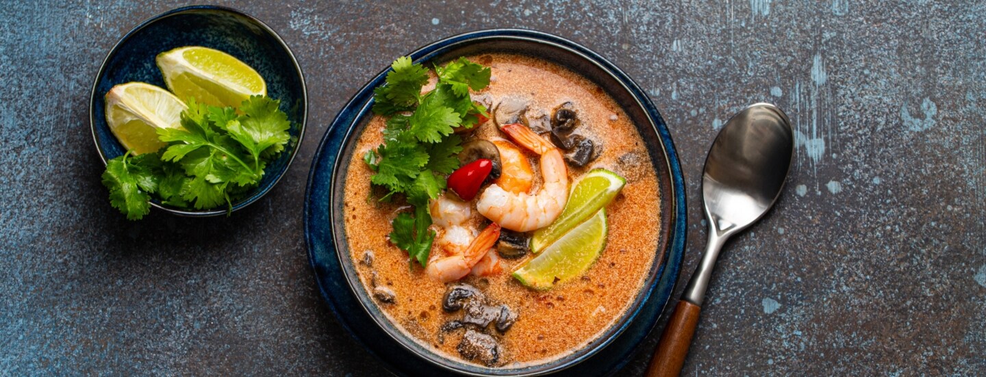 Thai-Suppe Tom Yum mit Meeresfrüchten in einer Keramikschüssel von oben