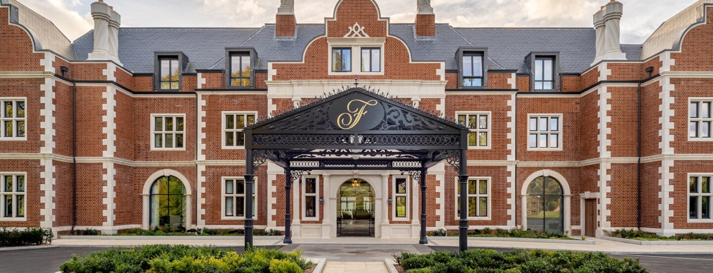 Außenfassade mit Eingangsbereich eines Luxushotels in einem Backsteingebäude.