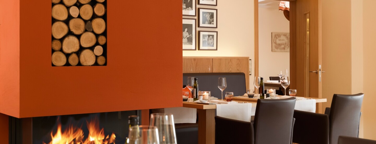 Kleiner Speisesaal eines gehobenen Restaurants mit Kamin.