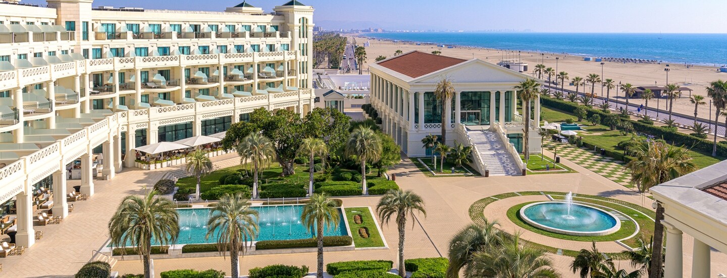 Luxuriöse Hotelanlage mit Pools und Palmengarten an einem breiten Sandstrand.