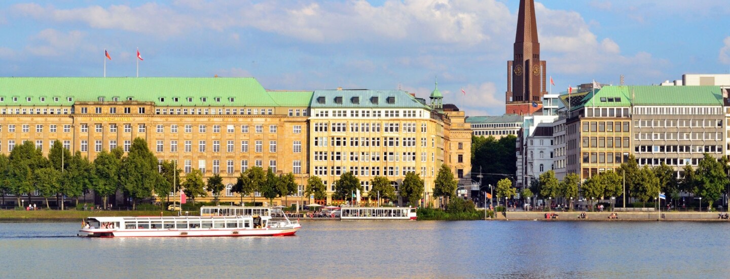 Häuserfront und Promenade am Wasser mit Booten in der Hamburger Altstadt.