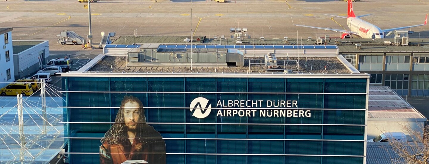 Aufsicht auf rechteckiges Hauptgebäude am Airport Nürnberg mit Albrecht Dürer Konterfei.