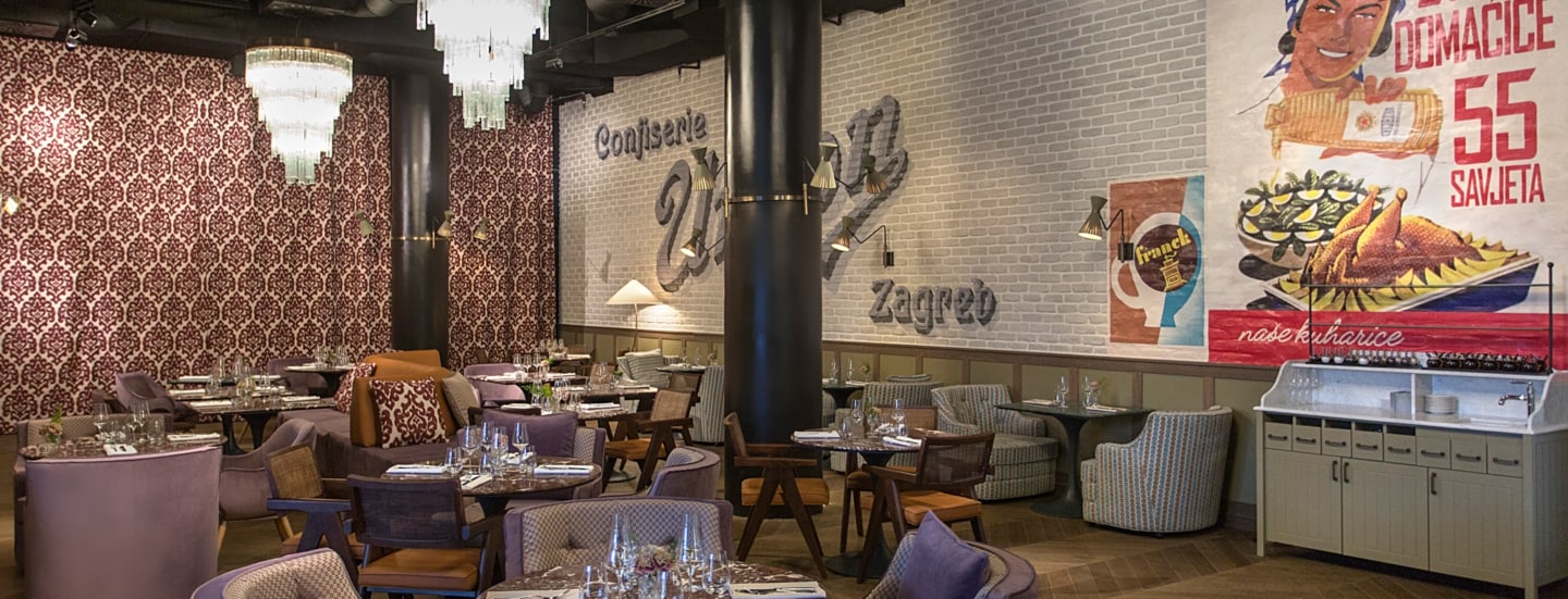 Restaurant mit eklektischem Einrichtungsstil und Werbeplakaten an der Wand.