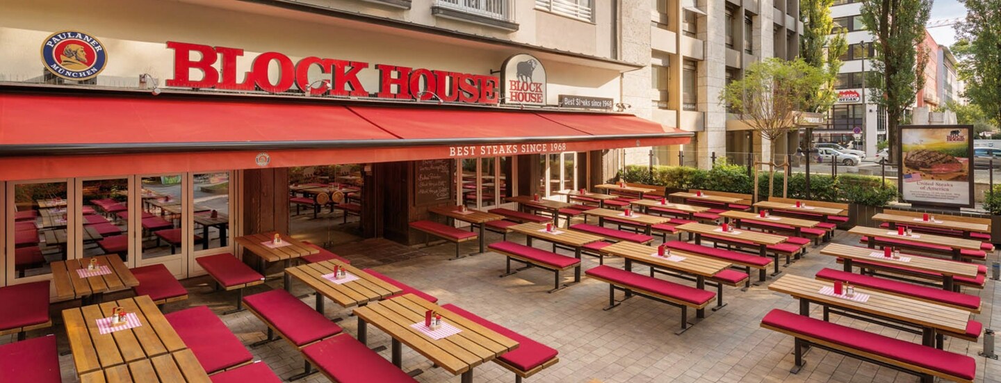 Block House Restaurant mit Außenterrasse in urbaner Umgebung.