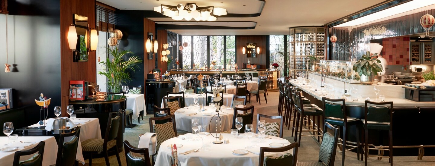 Edler Speisesaal mit eingedeckten Tischen und Barbereich in einem Luxusrestaurant.