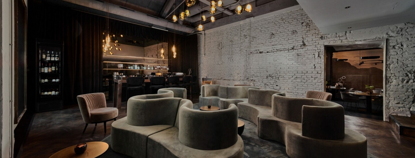 Gastraum in edlem Design, mit geschwungenen Polstermöbeln und einem Ambiente in Industriestil.