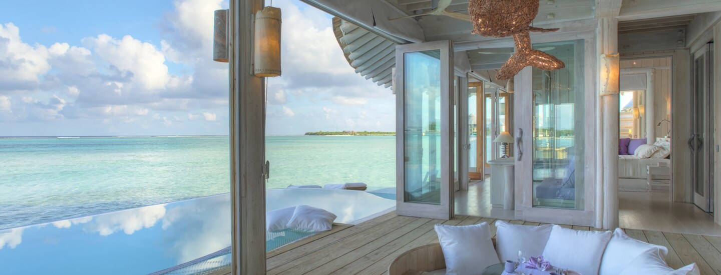 Luxuriöse Terrasse mit Sitzgarnitur einer Hotelsuite am türkisblauen Meer.