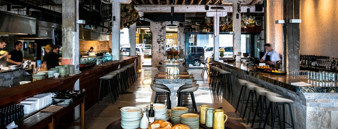 Modernes Restaurant im Industrie-Stil mit offener Küche und Bar.