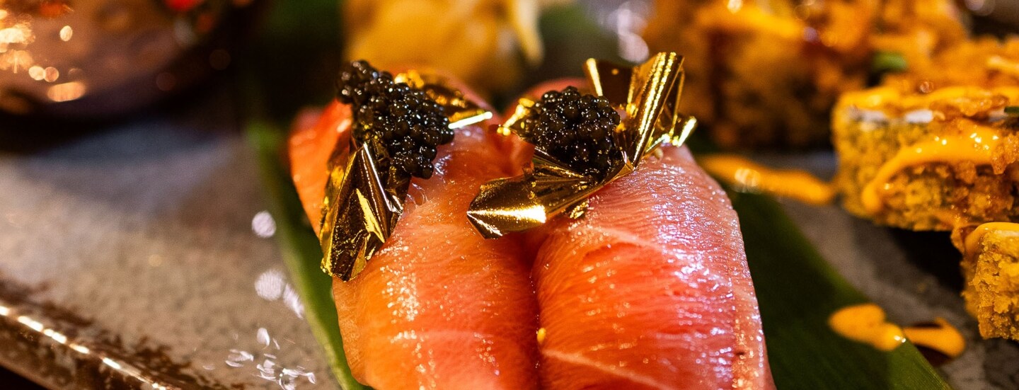 Nahaufnahme von edel angerichtetem Sashimi Sushi mit Blattgold und Kaviar.