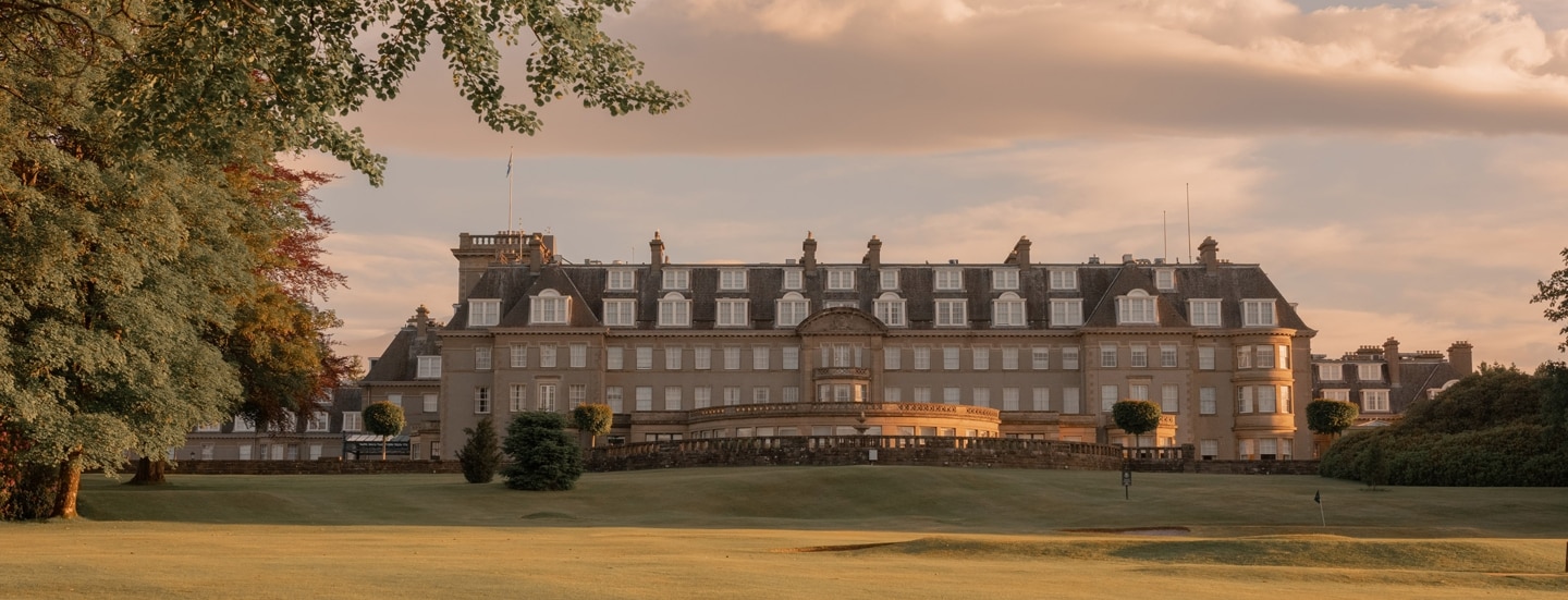 Ein luxuriöses Schlosshotel mit weitläufiger Rasenfläche in der Natur.
