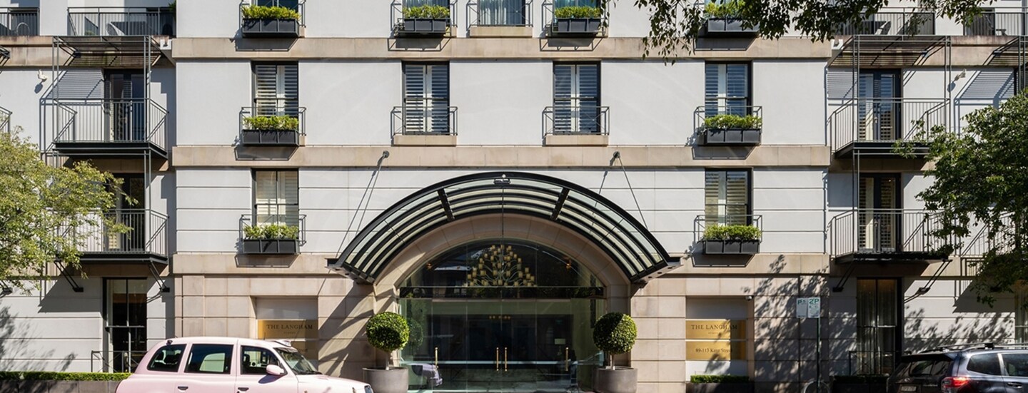 Hausfassade mit Hoteleingang mit Rundbogen.