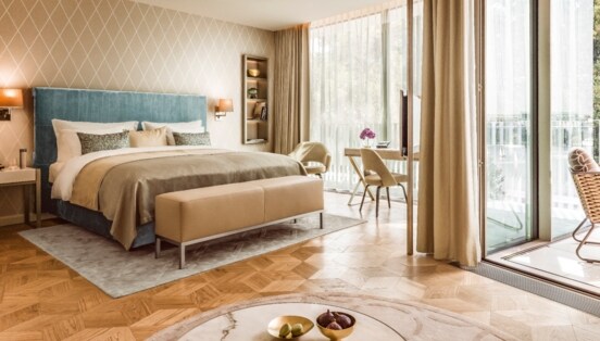 Moderne, helle Hotelsuite mit Parkettboden und bodentiefen Fenstern.