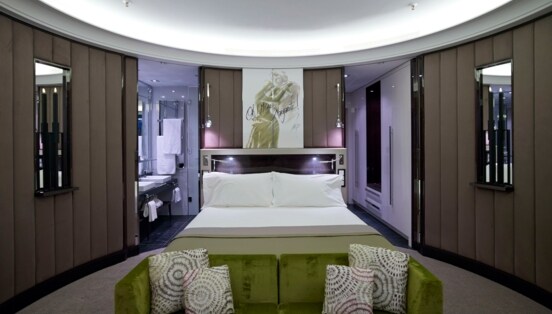 Eine moderne Hotelsuite mit runden Wänden und Doppelbett.