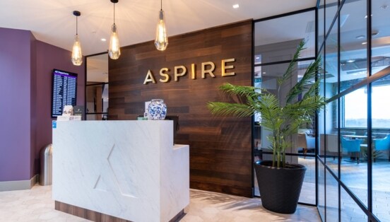 Eingangsbereich mit Rezeption einer Aspire Flughafenlounge.