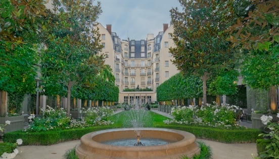 Außenfassade eines Grandhotels mit Gartenanlage.