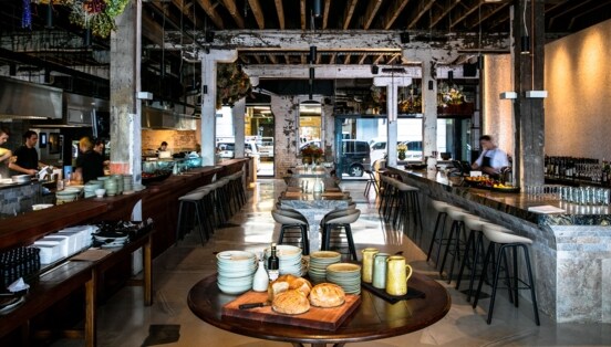 Modernes Restaurant im Industrie-Stil mit offener Küche und Bar.