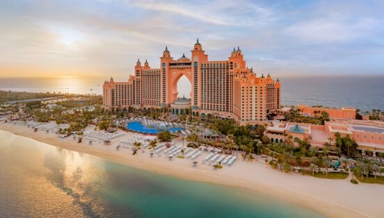 Luxuriöser Hotelkomplex mit Türmen auf einer Insel mit Gartenanlage und Pool an weißem Sandstrand.
