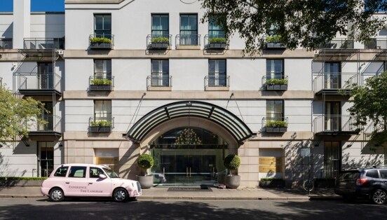 Hausfassade mit Hoteleingang mit Rundbogen.